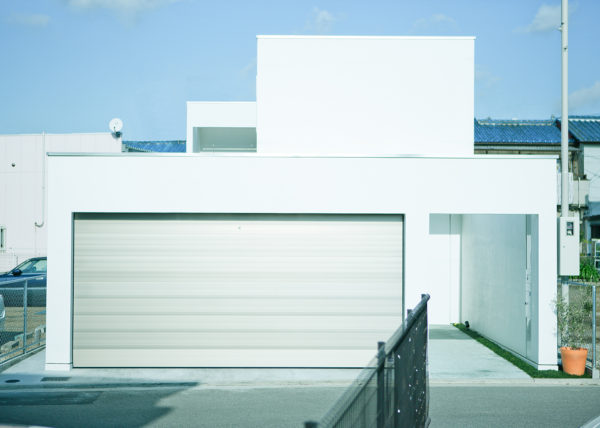 堺のガレージと中庭のある白い家